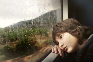 enfant regardant le paysage sous la pluie