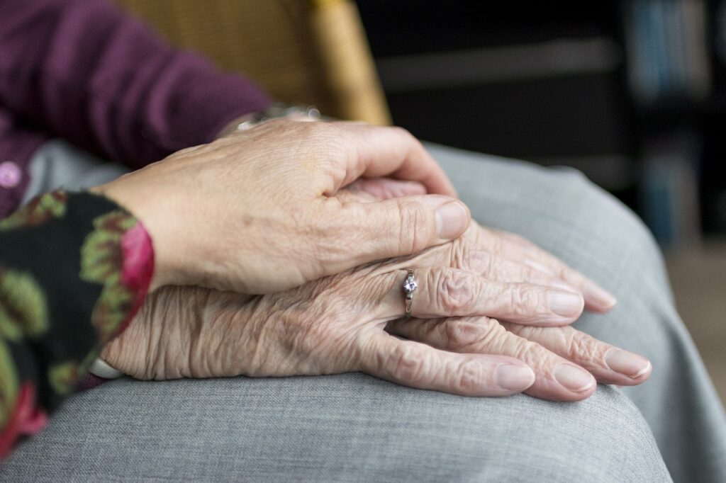 deux mains de personnes âgées pour les aider à travers une association caritative