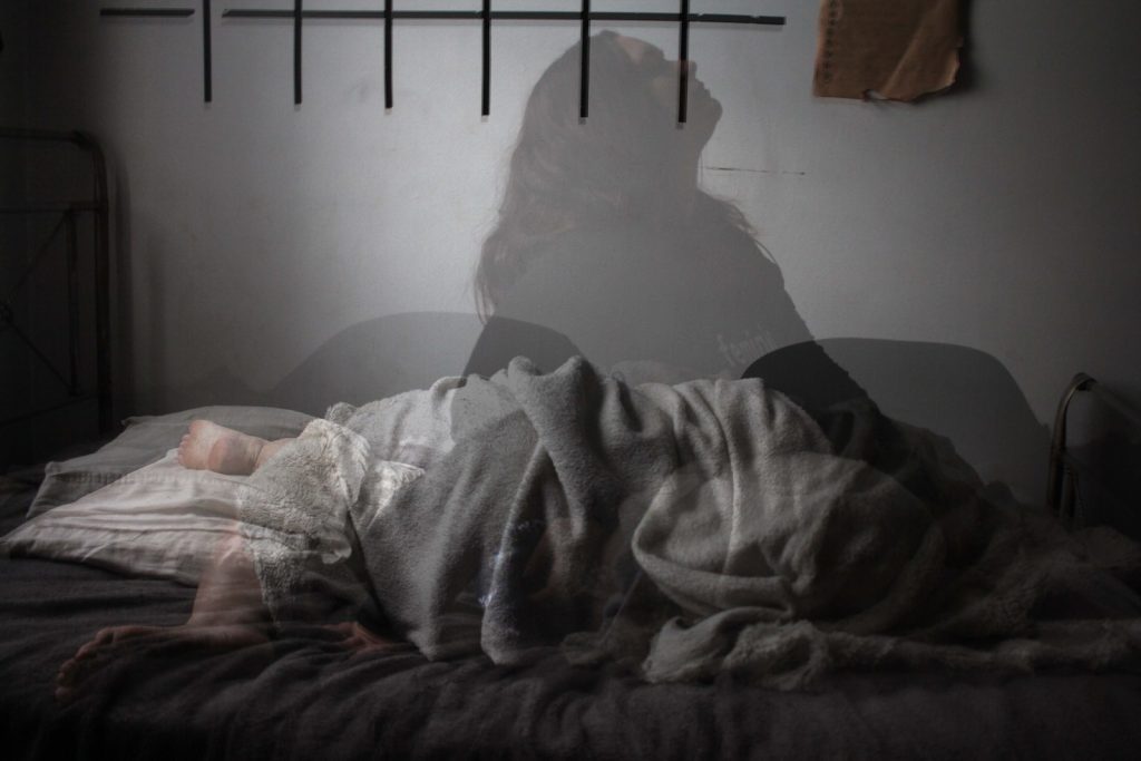 Une femme est allongée sur un lit dans une pièce.