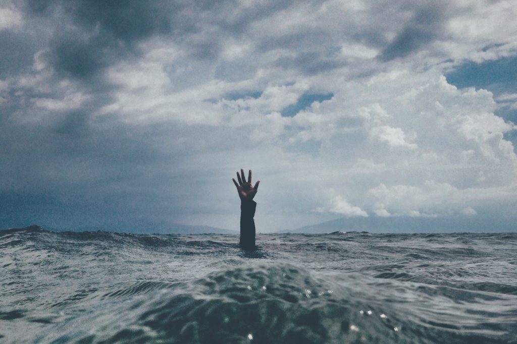 Une main sortant de l’eau dans l’océan.