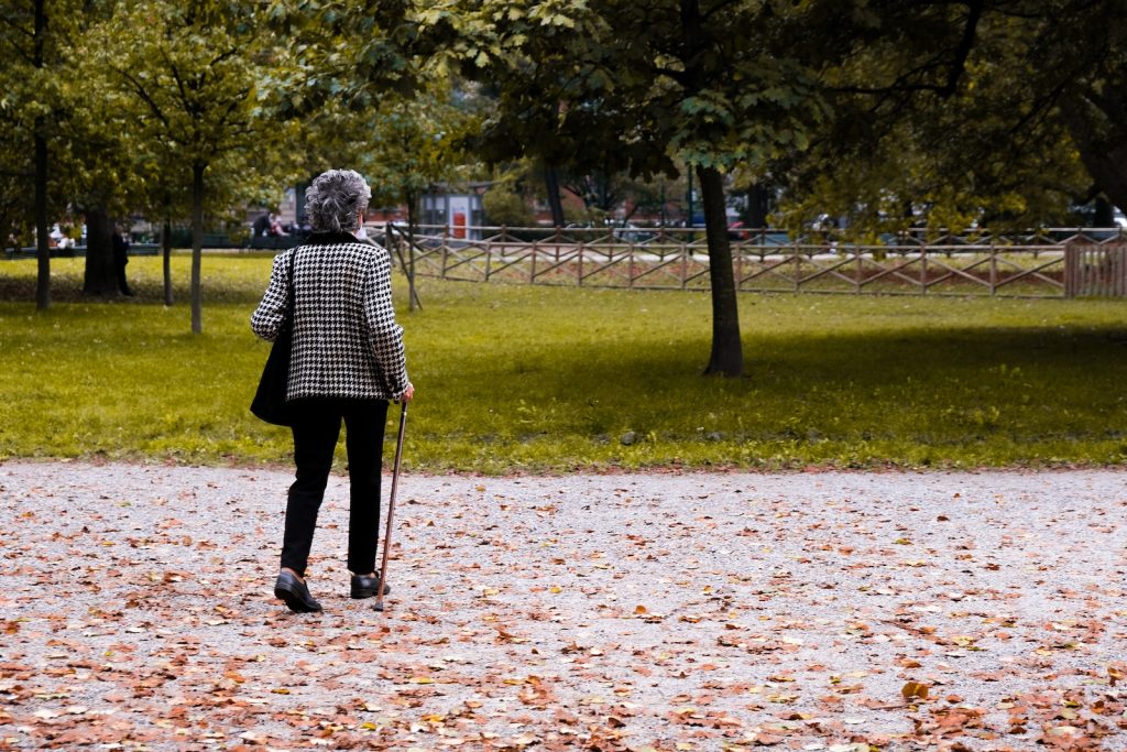 Une femme se promène dans un parc avec un cerf-volant à la main.