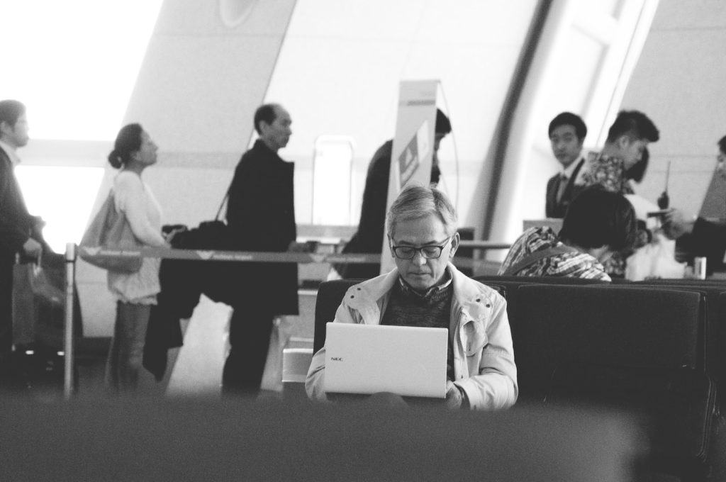 Une femme utilisant un ordinateur portable dans un aéroport.