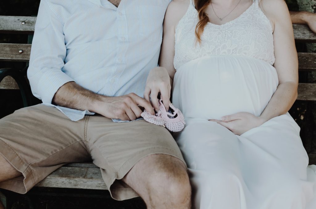 Un homme et une femme enceintes assis sur un banc.