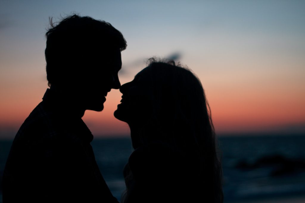 Une silhouette d'un couple s'embrassant au coucher du soleil.