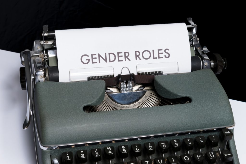 Une machine à écrire avec le mot rôles de genre dessus.